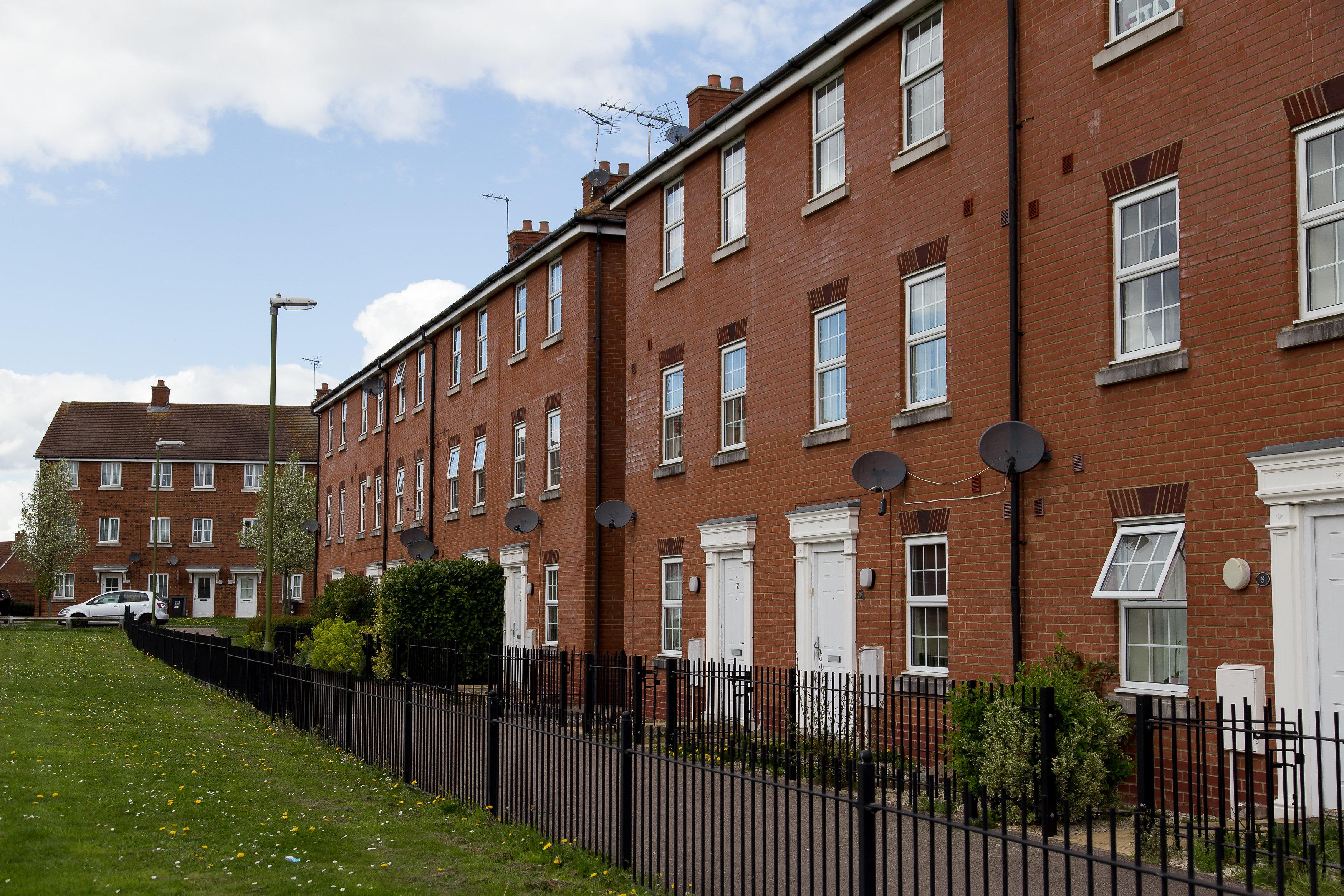 Row of terraced red brick, three storey houses